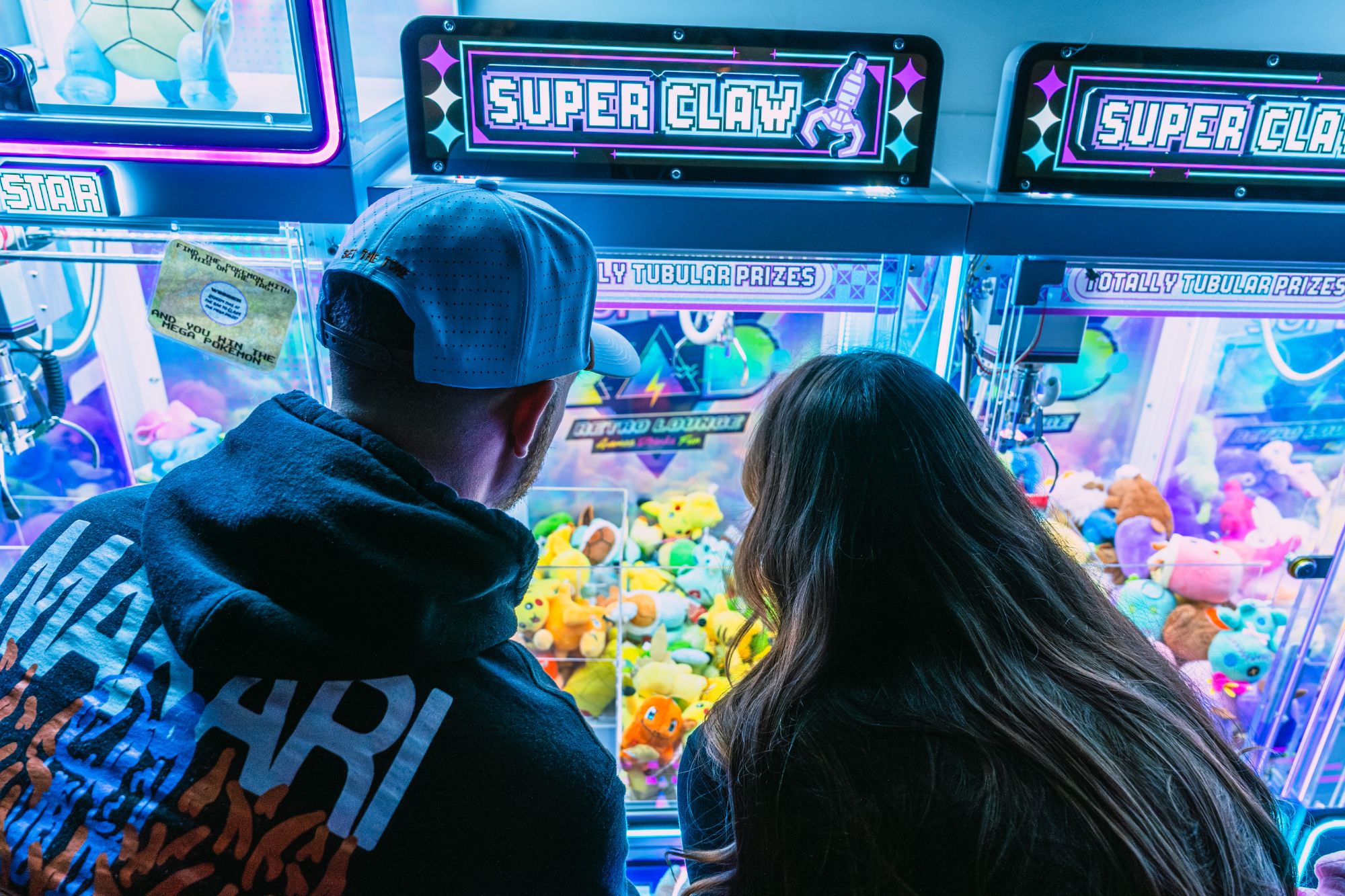 Couple playing the claw machine at Raleigh arcade bar
